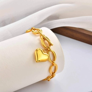 Bracelet chaîne en acier doré avec pendentif cœur et fermoir OT sur support blanc