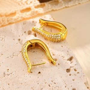 Macro view of gold-plated U-shaped earrings with micro-pave cubic zirconia accents