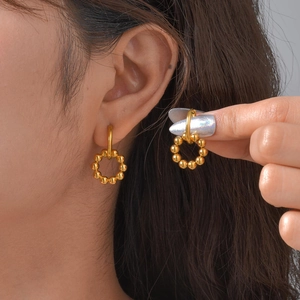 Golden stainless steel beaded hoop earrings for women shown on model for a trendy look