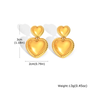 Détail des boucles d'oreilles cœur dorées montrant les dimensions et la texture torsadée