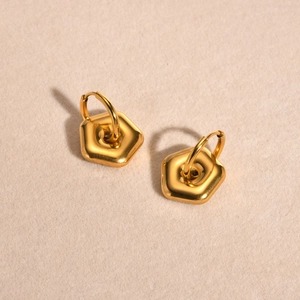 Detail view of gold geometric hexagonal hoop earrings with high-polish metallic finish