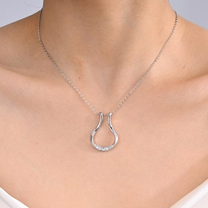 Dettaglio della collana minimalista in rame con ciondolo in zircone sul collo di modella