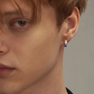Polished stainless steel ear hoop with non-binary pride flag enamel colors on male model