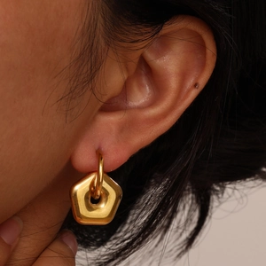 Minimalist gold stainless steel pentagon hoop earrings shown on female model ear