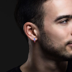 Close-up of small stainless steel hoop earring with blue and purple enamel details on male ear