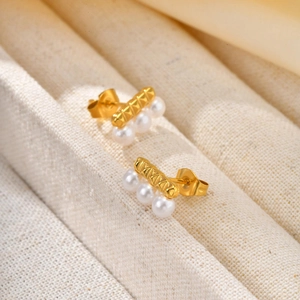 Elegant French style gold bar earrings with triple white pearls on textured fabric