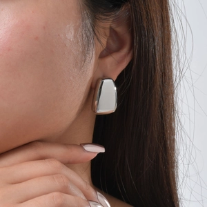 Close-up of geometric square stainless steel stud earring with polished silver mirror finish