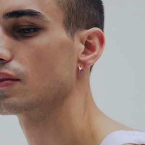 Detail of a man wearing a colorful enamel rainbow hoop earring in stainless steel