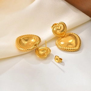 Détail de boucles d'oreilles double cœur plaquées or 18 carats avec texture torsadée