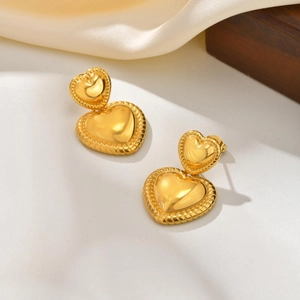 Vue détaillée de boucles d'oreilles double cœur dorées 18K avec texture de corde tressée