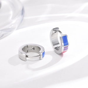 Detail of silver huggie earrings with colorful blue purple pink enamel stripes