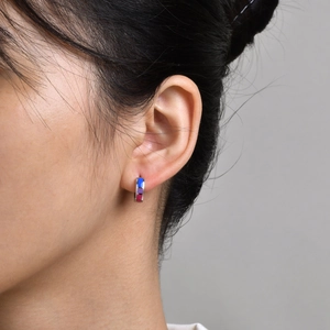 Close-up of small stainless steel hoop earring with blue and purple geometric inlay pattern