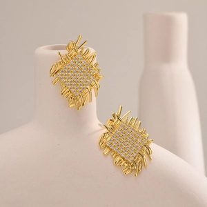 Detail of gold woven earrings featuring square pattern micro-pave zircon crystals