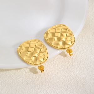 Close-up of gold wave-textured stud earrings with elegant 18K gold-plated diamond pattern