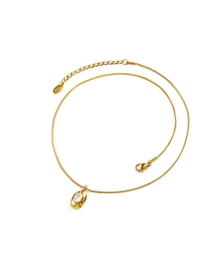 Detail of gold snake chain necklace with oval white zircon pendant and RIZ metal tag