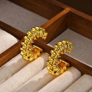 Detailed macro view of vintage croissant style gold C-shaped earrings with spiral texture