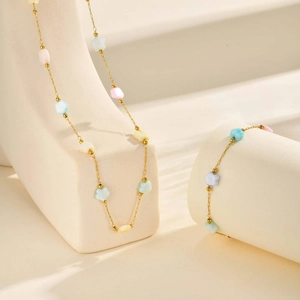 Detail view of gold-plated necklace and bracelet set with pastel floral beads