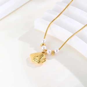 Elegant gold tropical fish pendant necklace with white pearls on a sleek snake chain