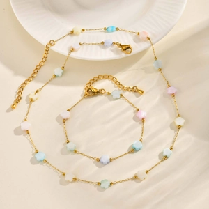Golden necklace and bracelet set with colorful macaron star beads on ceramic plate