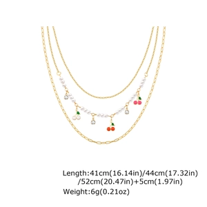Detailed view of layered cherry pendant necklace with pearls and rhinestone charms