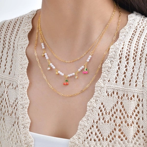 Three-layer gold cherry necklace set with imitation pearls and pendants on a model