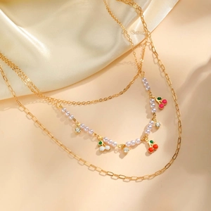 Layered gold necklace featuring pearl strands, cherry pendants, and crystal accents for women