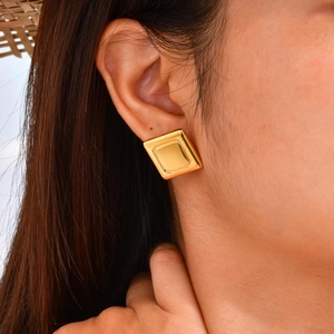 Classic gold square stud earrings for women shown on model in minimalist fashion style