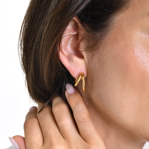 Gros plan d'élégantes boucles d'oreilles doubles créoles plaquées or 18 carats sur le mannequin