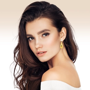 Gros plan de boucles d'oreilles goutte d'eau dorées avec zircon blanc sur un mannequin