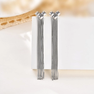 Détail macro de boucles d'oreilles cœur origami en argent avec de longs pompons