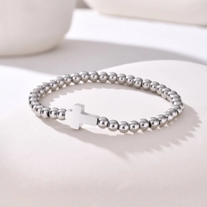 Détail du bracelet de perles minimaliste en acier inoxydable avec pendentif en croix