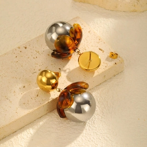 Close-up of vintage flower earrings with amber resin petals and silver mirror spheres