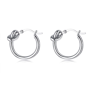 Gros plan de boucles d'oreilles créoles à nœud en argent poli au design épuré et fermeture