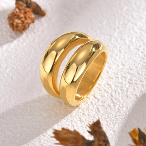 Two polished gold minimalist stainless steel geometric rings on a textured background