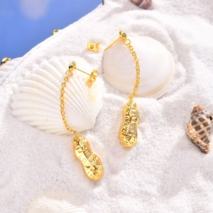 Golden stainless steel peanut tassel earrings on white sand beach with seashells