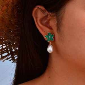 Close-up of elegant flower earring with green malachite texture and water drop pearl
