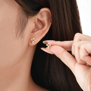 Boucles d'oreilles croix dorées avec cristaux zircon et pierre rouge sur oreille