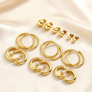 Three-piece gold stainless steel hoop and ball stud earring set on champagne silk fabric