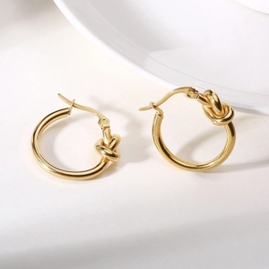 Boucles d'oreilles créoles nouées design français en acier titane doré pour femme