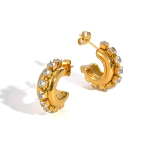 Detailed view of gold C-shaped earrings with sparkling cubic zirconia pavé and butterfly backs
