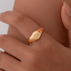 Bague chevalière ovale élégante en acier inoxydable doré portée par un mannequin
