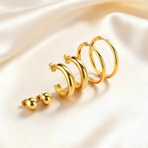 Three-piece set of gold-plated stainless steel hoop and ball stud earrings on silk
