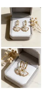 Détail de boucles d'oreilles ginkgo avec nacre blanche et bords en zircon plaqué or