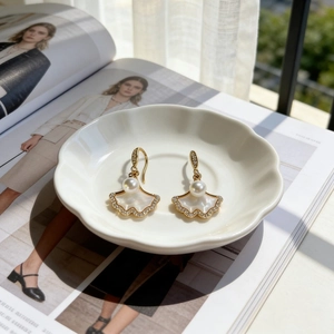 Boucles d'oreilles feuilles de ginkgo dorées avec nacre et perles sous le soleil