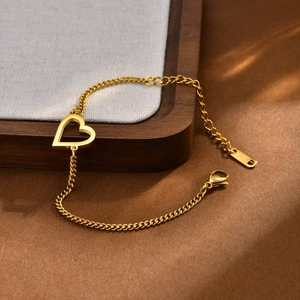 Dettaglio del bracciale con cuore dorato che mostra l'incisione K18 e la chiusura a moschettone