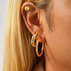 Three-piece gold stainless steel earring set featuring ball studs and hoops for layering