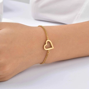 Dettaglio del ciondolo a cuore cavo dorato e chiusura a moschettone del bracciale
