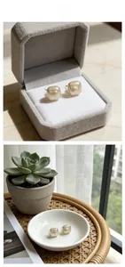 Detailed close-up of luxury pearl stud earrings in gold finish on a soft velvet display