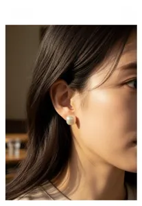 Close-up of a square sugar pearl stud earring worn on the ear showing premium texture