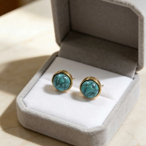 Retro round turquoise stud earrings with gold plating on a gray velvet jewelry box